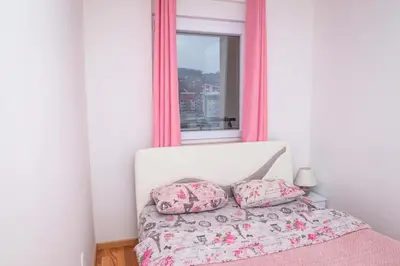 a bed with two pillows in a bedroom with a mirror at Apartman Royal 2 in Doboj
