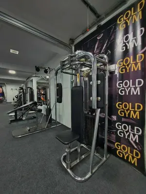 a gym with several tread machines and a chair at Gold Apartmani Kozarac in Kozarac