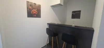 a room with two blue chairs and a black counter at Gold Apartmani Kozarac in Kozarac