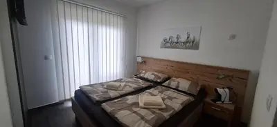 a bedroom with a bed with two pillows on it at Gold Apartmani Kozarac in Kozarac