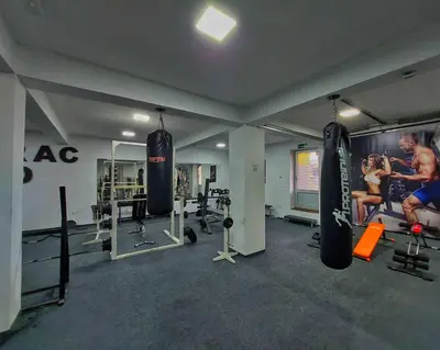 a gym with two people in a room with weights at Gold Apartmani Kozarac in Kozarac