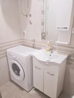 a bathroom with a washing machine and a sink at Apartman Istra, Doboj in Doboj