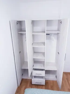a white closet with white shelves and a rug at Apartman Istra, Doboj in Doboj