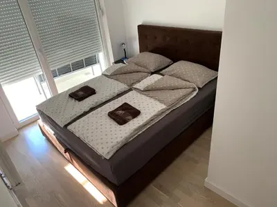 a bedroom with a bed with two pillows on it at Apartman Tuzla - Blizu Panonskih jezera i centra grada in Tuzla