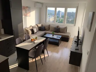 a living room with a couch and a table at Apartman Tuzla - Blizu Panonskih jezera i centra grada in Tuzla