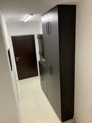 a kitchen with a black and white cabinet and a door at Apartman Tuzla - Blizu Panonskih jezera i centra grada in Tuzla