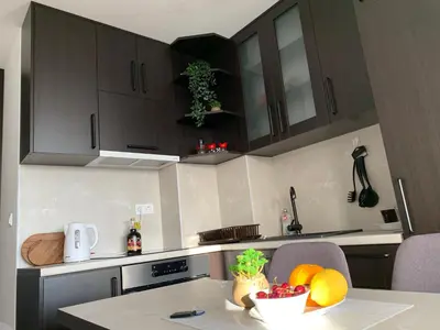 a kitchen with a table with a bowl of fruit on it at Apartman Tuzla - Blizu Panonskih jezera i centra grada in Tuzla