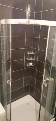 a bathroom with a shower with black tiles at Apartman Casa Banja Luka in Banja Luka