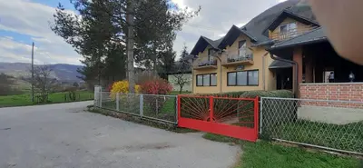 a house with a red gate in front of it at Smještaj na selu,porodica Gvozdenac in Šipovo