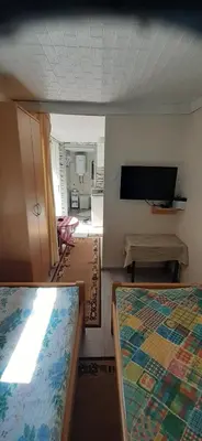 a room with two beds and a flat screen tv at Smještaj na selu,porodica Gvozdenac in Šipovo