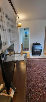 a living room with a table and a television and a rug at PURE NATURE in Visoko