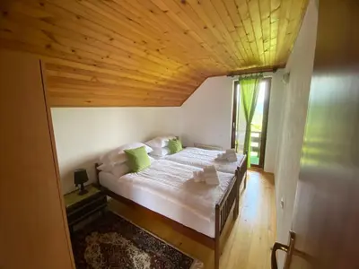 a bedroom with a large bed with a wooden ceiling at PURE NATURE in Visoko