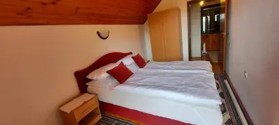 a bedroom with a bed with red and white pillows at PURE NATURE in Visoko