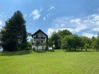 a house on top of a green field with trees at PURE NATURE in Visoko