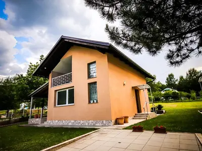 a small orange house with a green yard at My Eden Bihać in Mahala