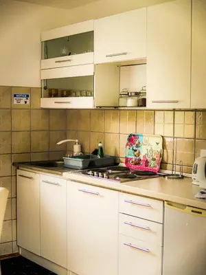 a kitchen with white cabinets and a counter top at My Eden Bihać in Mahala