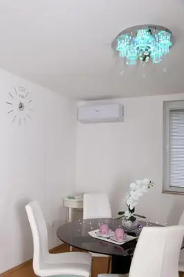 a dining room with a glass table and white chairs at My Eden Bihać in Mahala