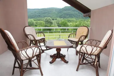 a group of chairs and a table on a porch at My Eden Bihać in Mahala
