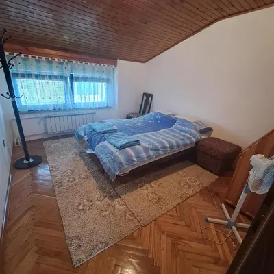 a bedroom with a bed in the corner of a room at Villa Behić in Bihać