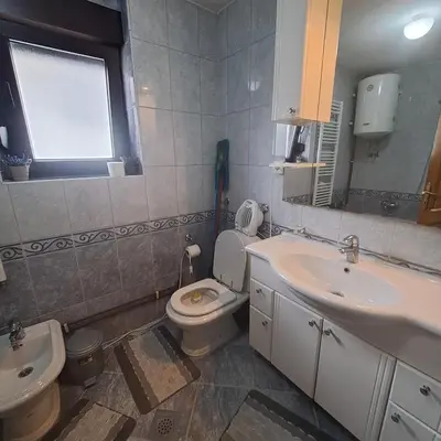 a bathroom with a toilet and a sink and a mirror at Villa Behić in Bihać