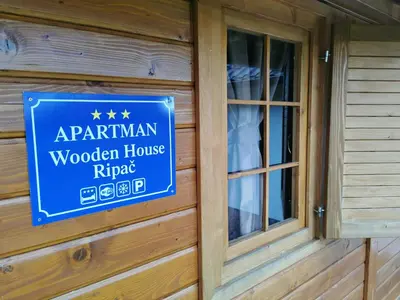 a blue sign on the side of a wooden house at Wooden House Ripac in Bihać