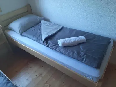 a bed with a pillow sitting on top of it at Wooden House Ripac in Bihać