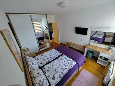 a small bedroom with a bed and a mirror at Best Location - Heart Of Tuzla in Tuzla