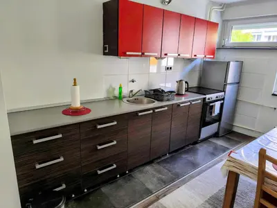 a kitchen with red cabinets and a sink at Apartman Banja Luka 2 in Banja Luka