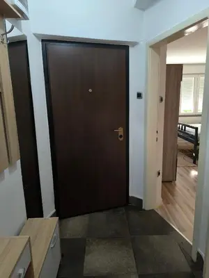 a brown door in a room with a hallway at Apartman Banja Luka 2 in Banja Luka