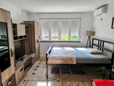 a bedroom with a bed and a tv and a window at Apartman Banja Luka 2 in Banja Luka