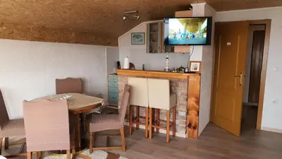 a kitchen with a table and a television on the wall at Medena oaza mira in Visoko
