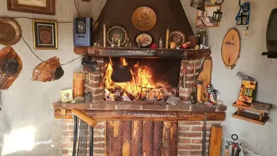 a brick fireplace with a fire in it at Medena oaza mira in Visoko