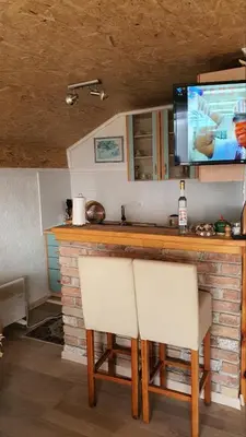 a kitchen with two chairs and a bar with a tv at Medena oaza mira in Visoko