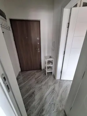a hallway with a wooden door and a small table at Apartman Lilly in Modriča