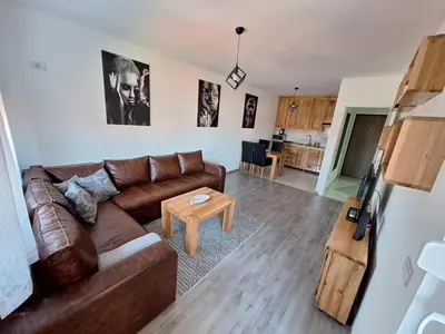 a living room with a brown couch and a table at Apartman Lilly in Modriča