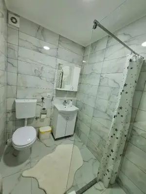a white bathroom with a toilet and a sink at Apartman Lilly in Modriča