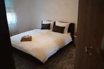 a bedroom with a large bed with two towels on it at apartman Vidović in Livno