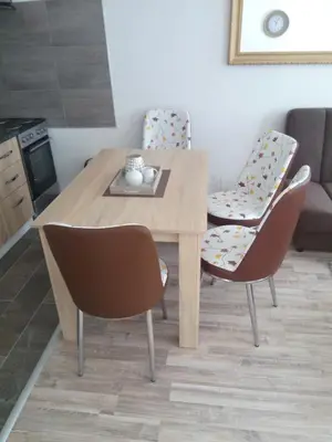 a wooden table and chairs in a living room at apartman Vidović in Livno