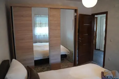 a large mirror in a room with a bed at apartman Vidović in Livno