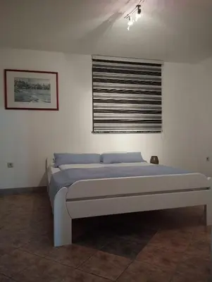 a bed in a room with a window and a bedvisor at City villa Bihac in Bihać