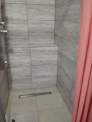a bathroom with a shower with a tiled floor at City villa Bihac in Bihać
