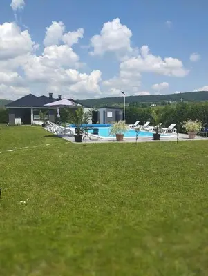 a house with a swimming pool in a grass field at City villa Bihac in Bihać