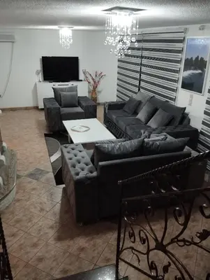 a living room with black couches and a table at City villa Bihac in Bihać