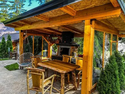 a wooden pavilion with a table and a stove at Vila Bašić Vlašić Spa Apartman JELEN in Vlasic