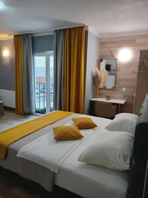 a bedroom with a large bed with yellow pillows at Motel Liberta in Jajce