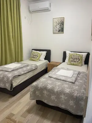 two beds in a room with green curtains at Motel Liberta in Jajce