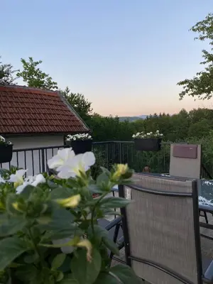 a balcony with a table and chairs and flowers at Ravne Rest House in Visoko