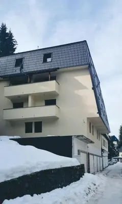 a building with a staircase on the side of it in the snow at Apartman Spirit of Vlašić in Vlasic