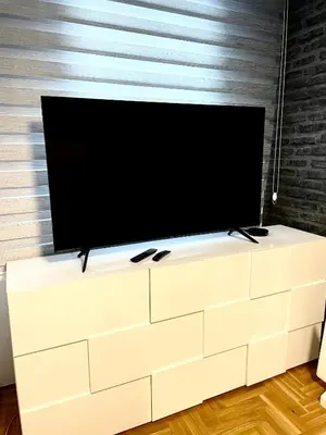 a flat screen tv sitting on top of a white dresser at Apartman CITY CENTER 3-šetalište in Prijedor