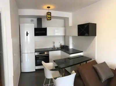a small kitchen with a table and a refrigerator at Apartman CITY CENTER 3-šetalište in Prijedor